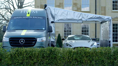 Van with awning and car